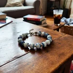 Collier anti tique chien céramique sur table en bois avec livres et café en arrière-plan