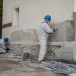 Travailleurs traitant une façade contre l'humidité sur chantieraccess.fr pour rénovation extérieure efficace