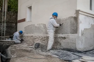 Travailleurs traitant une façade contre l'humidité sur chantieraccess.fr pour rénovation extérieure efficace