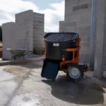 Bétonnière sur chantier devant murs en parpaings avec matériel chantieraccess fr à proximité