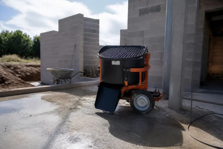 Bétonnière sur chantier devant murs en parpaings avec matériel chantieraccess fr à proximité