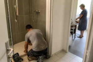 Homme rénovant une douche avec l'intervention de la société la force de l'âge rénovation
