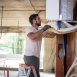 Technicien installe un système de climatisation dans un bâtiment pour Mon Institut du BTP