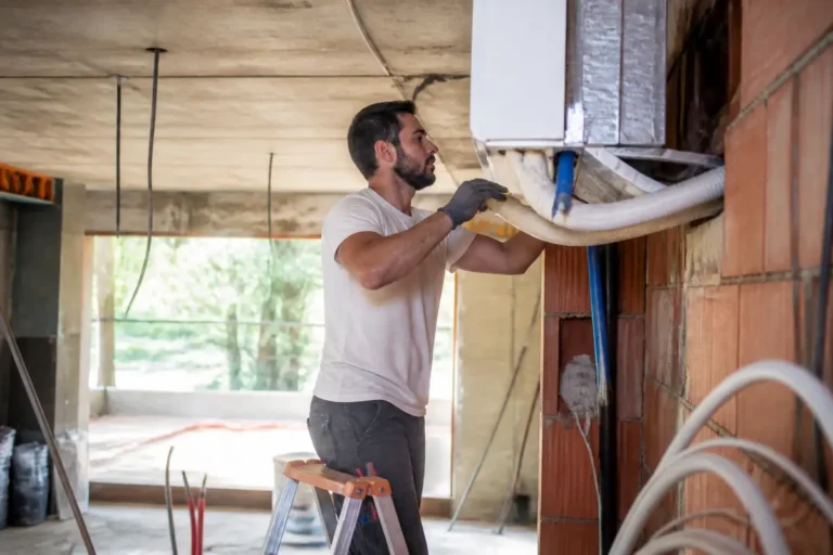 Technicien installe un système de climatisation dans un bâtiment pour Mon Institut du BTP