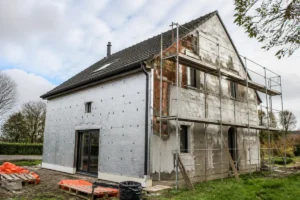 Maison en rénovation avec isolation thermique complète par tousrenov.be et échafaudages visibles.